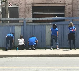BMO employees painting a fence at BMO Volunteer Day 2019