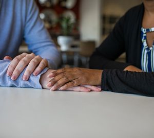 One hand touching another hand in a comforting gesture