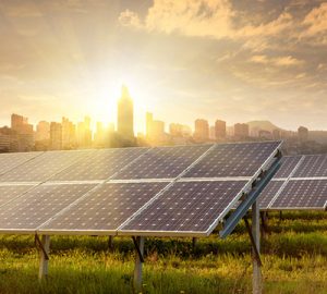 An array of solar panels with buildings in the background