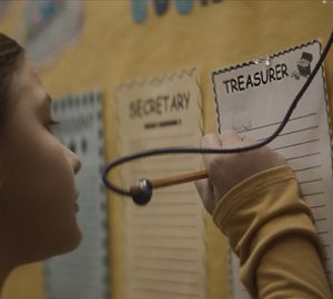 A little girl signs up for the position of treasurer