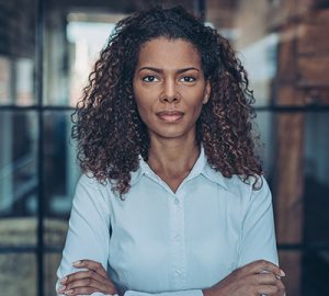A woman of color with her arms crossed
