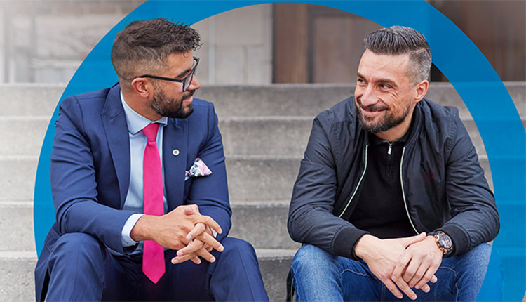 Two men chatting on the steps outside a building