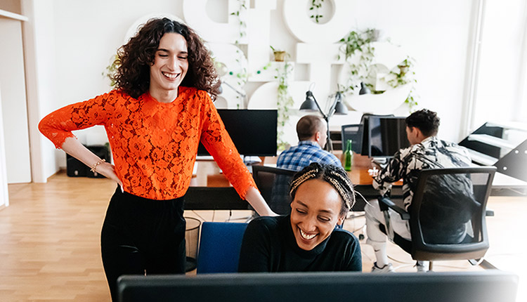 Two women of colour wokring in front of a computer